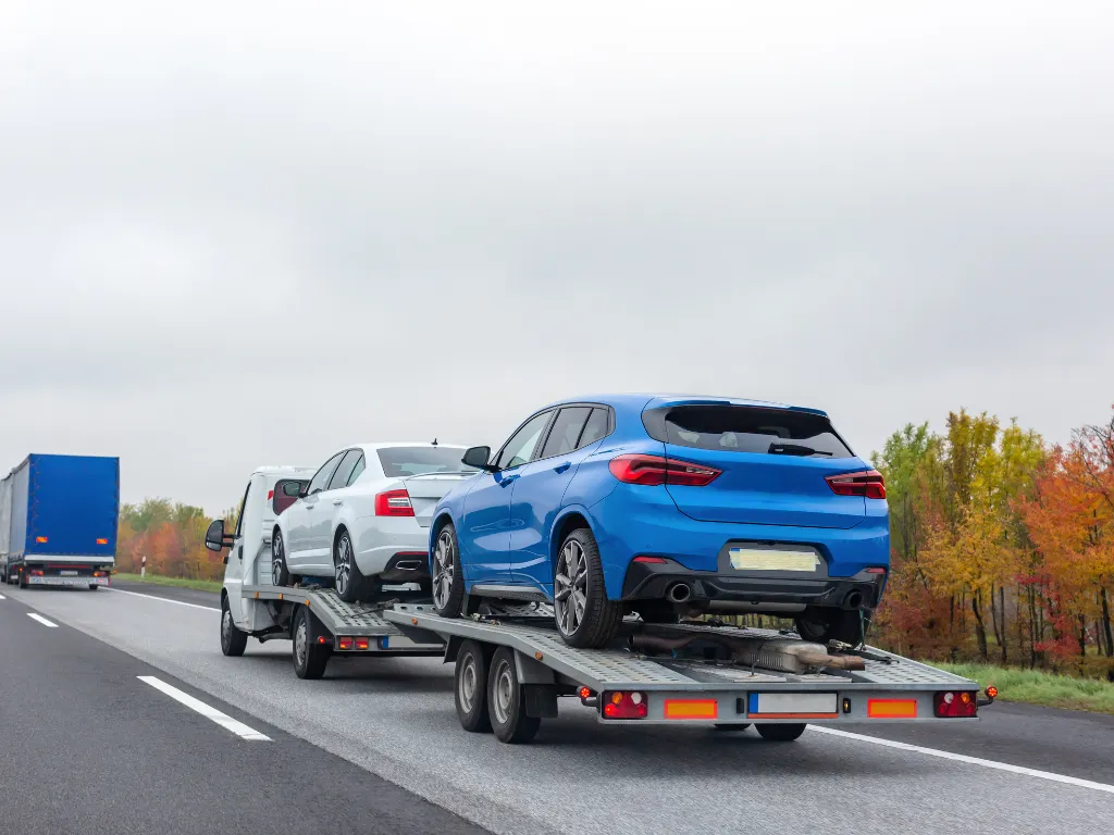 Camión con dos autos en la carretera interestatal